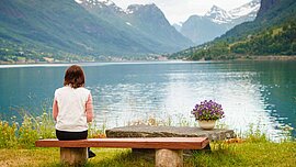 Frau am Ufer eines Fjord bei Olden, Norwegen