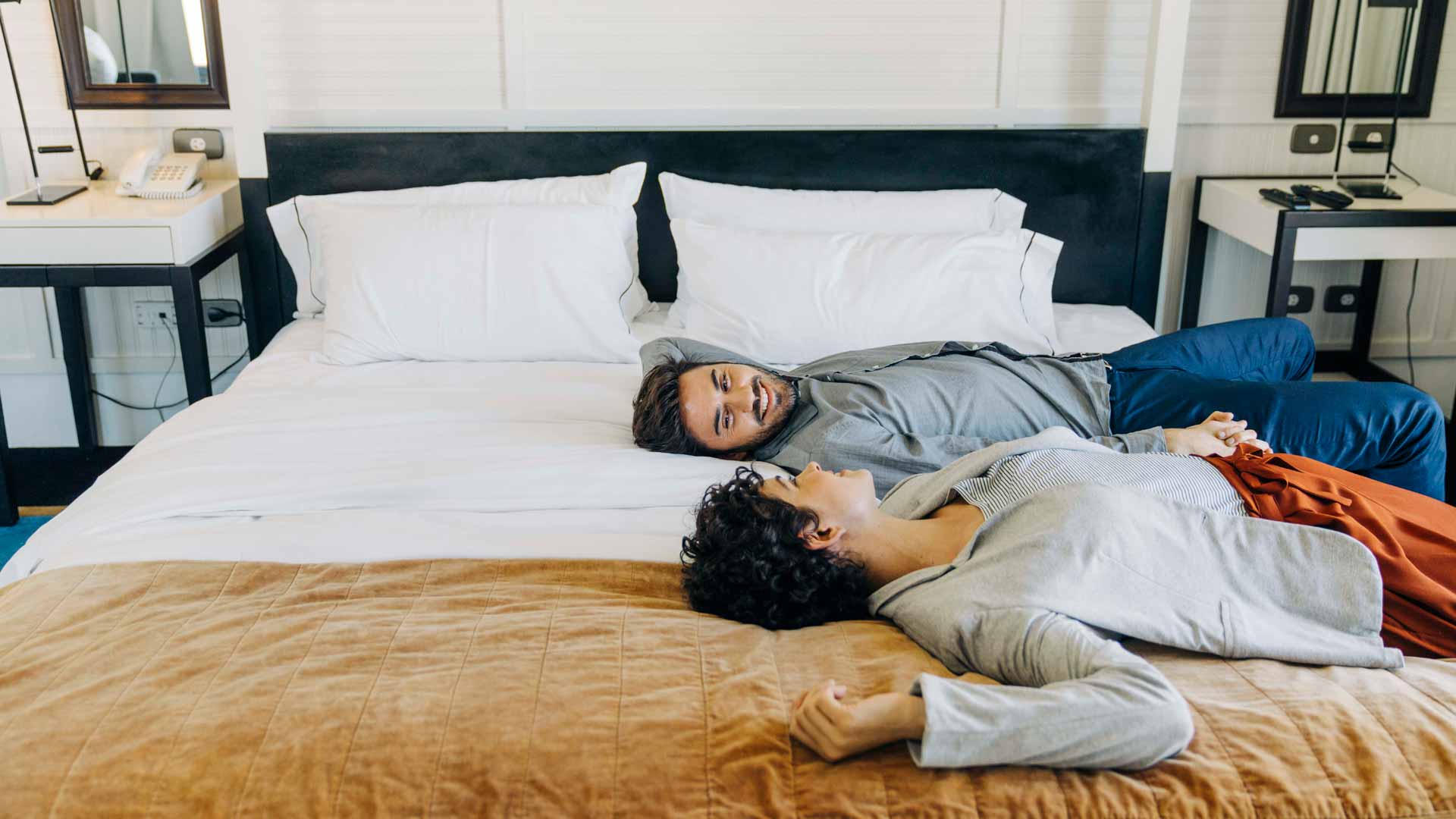 Glückliches Paar im Hotelzimmer auf Ihrem Bett